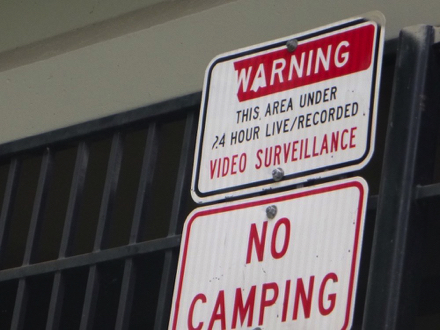 Sign under the freeway – no camping – warning, this area under 24 hour live/recorded video surveillance